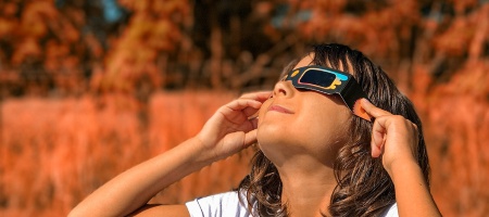 Mädchen schaut sich die Sonnenfinsternis mit Brille an